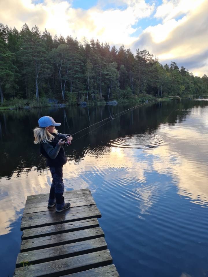 Flicka som fiskar på en brygga