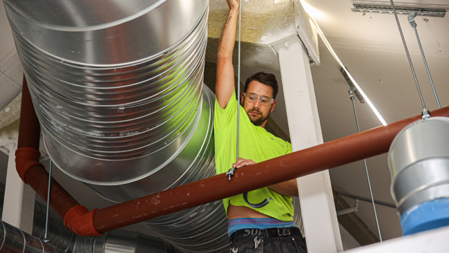 Montör som sätter ventilation i tak