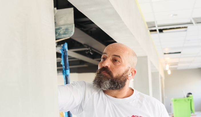 Målare som spacklar en vägg