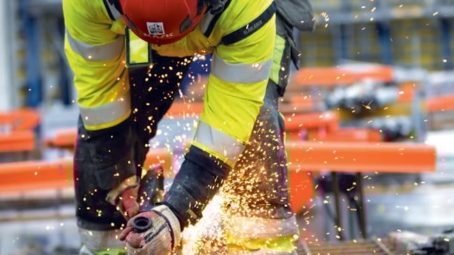 Byggnadsarbetare sågar i armering
