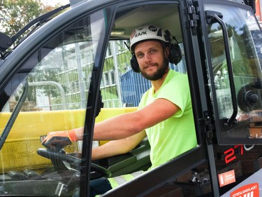 Byggnadsarbetare sitter i en gaffeltruck