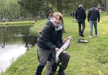 Sex män framför fiskedamm