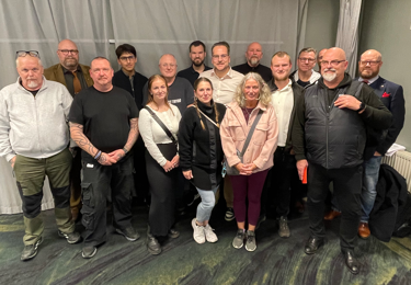 Män och kvinnor som tittar in i kameran.