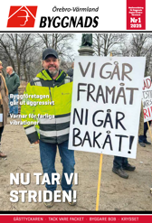 En person i arbetskläder med en skylt