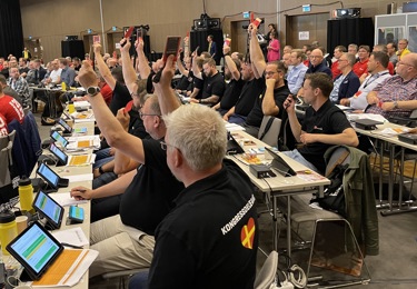 Människor som håller upp röstkort.