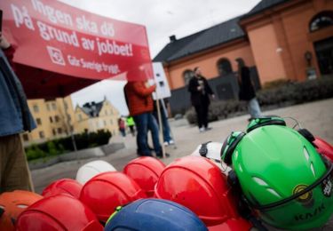Bild från manifestationen i Hörsalsparken 2024. Hjälmar på marken representerar antalet avlidna byggnadsarbetare under 2023.