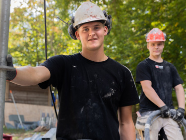 Två lärlingar som arbetar med att mura