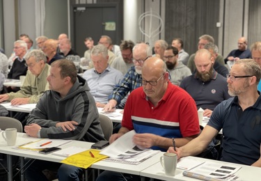 Många sittande människor i möteslokal.