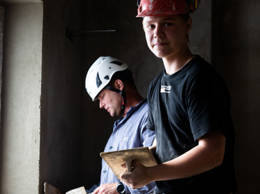 Två murare som putsar en vägg