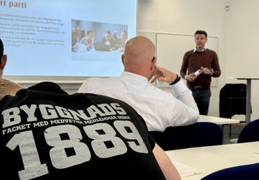 På bilden syns Niklas Karlsson, ordförande för Socialdemokraterna i Skåne, och en t-shirt med texten Byggnads 1889.