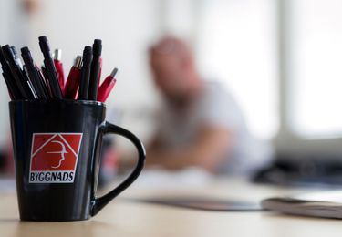 En byggnadskopp med pennor på konferensbordet vid ett möte