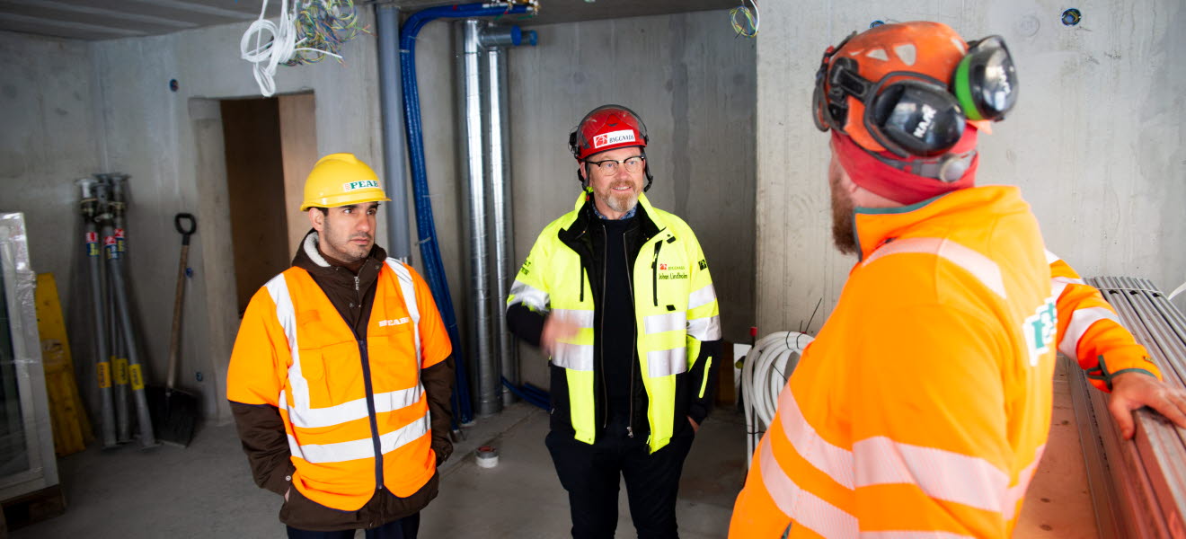 Ardalan Shekarabi och Johan Lindholm pratar med en byggnadsarbetare