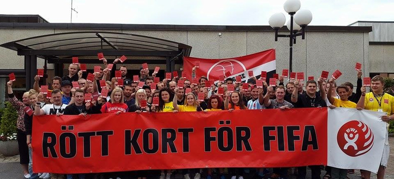 Många personer som håller upp varsitt rött kort samt en banderoll med texten Rött kort för Fifa