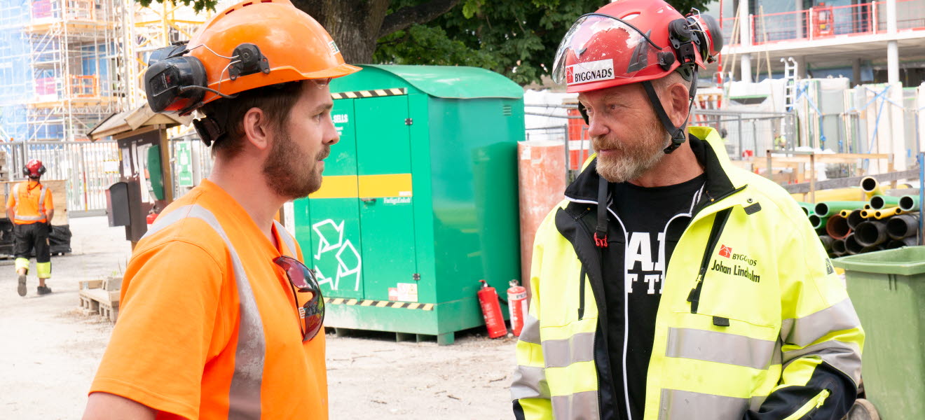 Johan Lindholm pratar med en byggnadsarbetare.