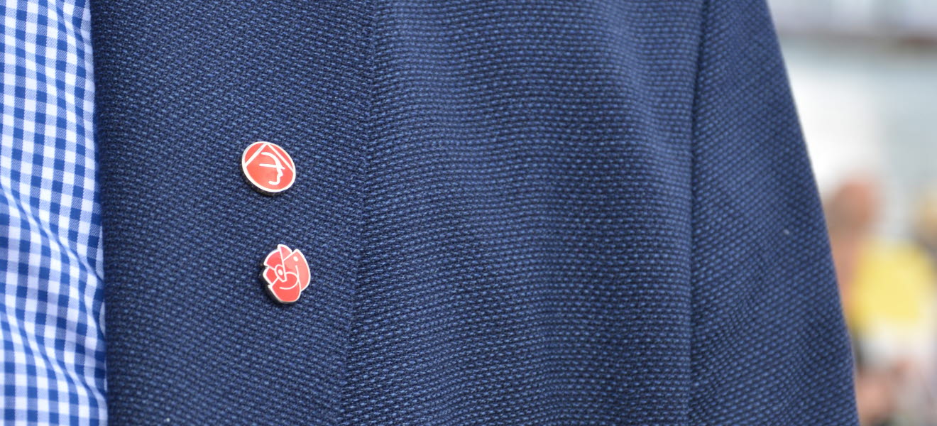 Kavajslag med en Byggnads-pin och en socialdemokraterna-pin.