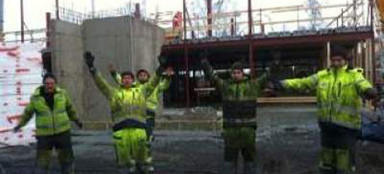Byggnadsarbetare gör morgongymnastik